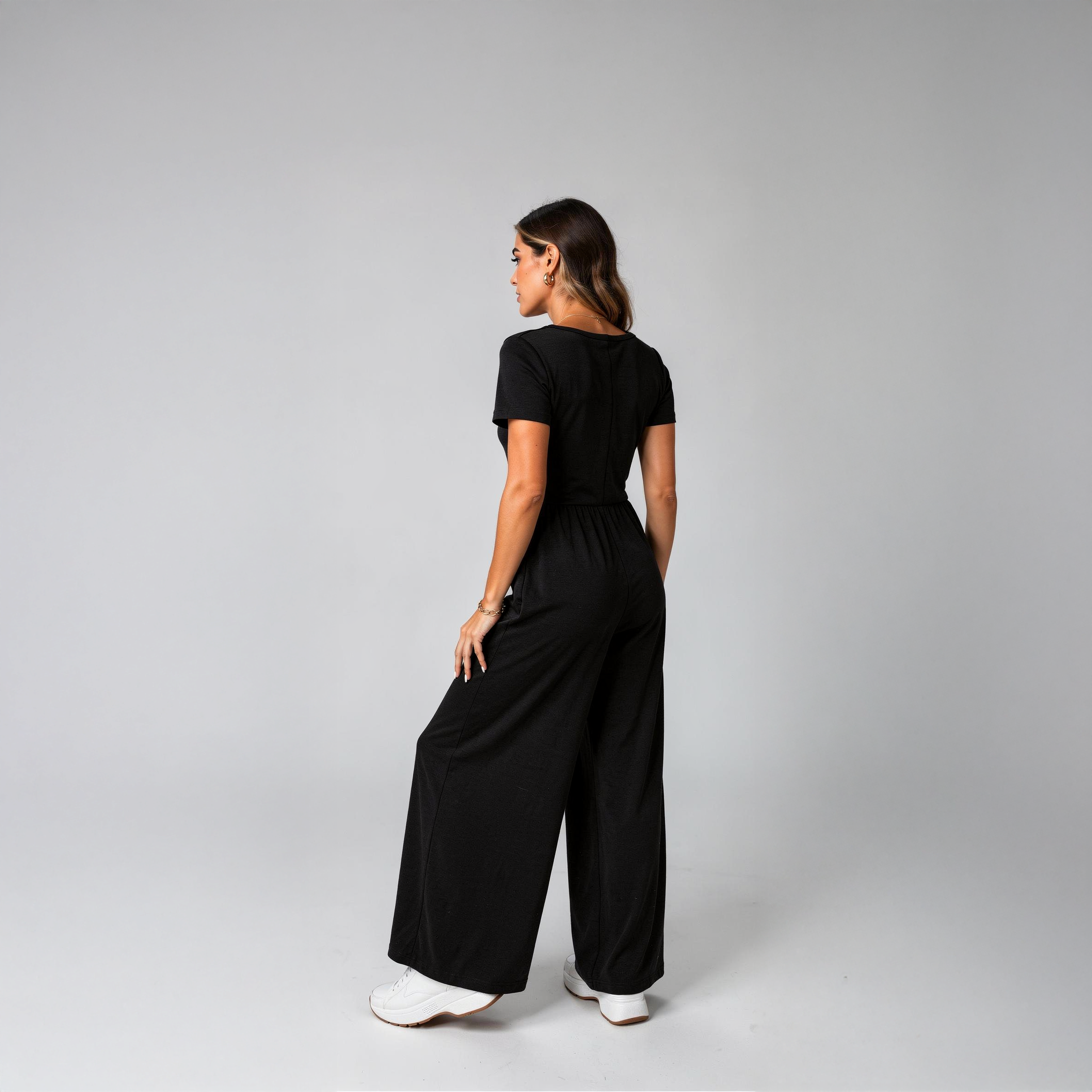 Tailored black wide-leg jumpsuit for women with a flattering V-neckline and defined waist, photographed in a clean studio setting.
